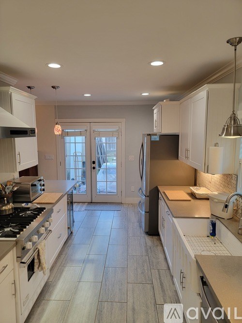 A kitchen with a tile floor and a refrigerator.