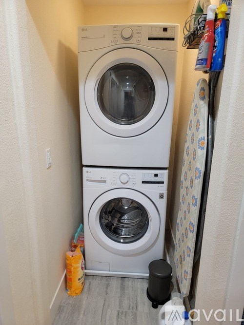 A white front loading washing machine in a small laundry room.