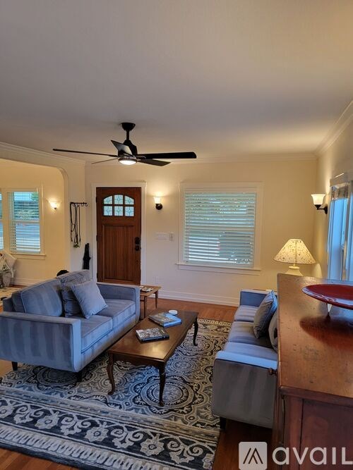 A living room with a grey couch and a wooden coffee table.