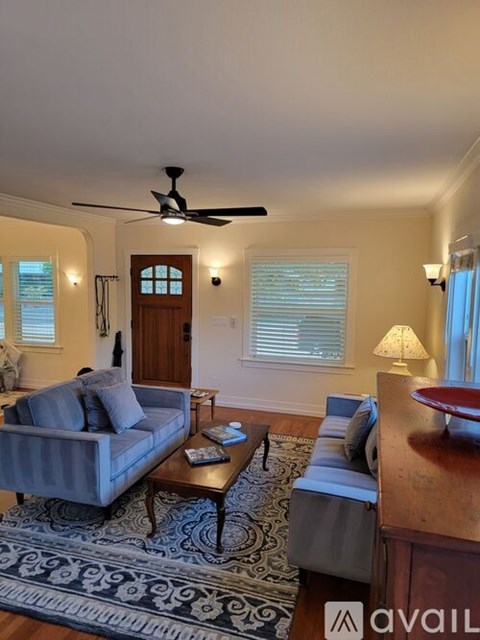 A living room with a grey couch and a wooden coffee table.