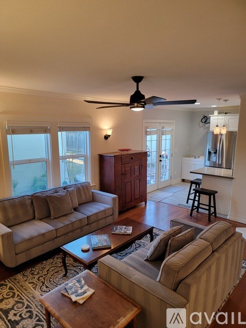 A room with a white wall and a wooden floor with a cardboard box and a wooden plank.