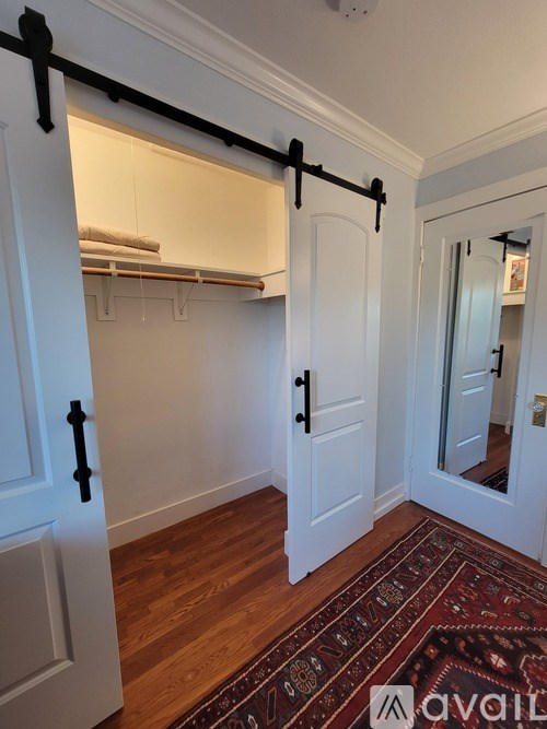 A kitchen with white cabinets and a stainless steel refrigerator.