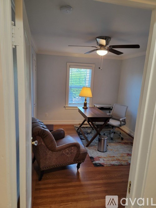A bedroom with a bed, a rug, a ceiling fan, and a window.