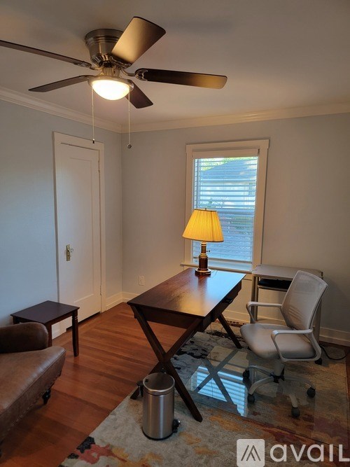 A room with a brown table and a white chair.