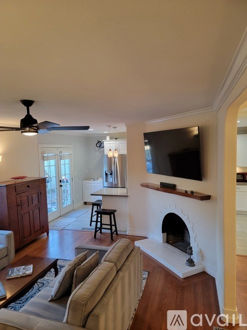 A living room with a couch, a fireplace, and a television.