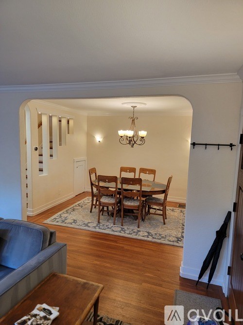 A dining room with a wooden table and chairs.