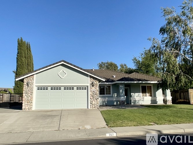 A house with a garage and a driveway in front of it.