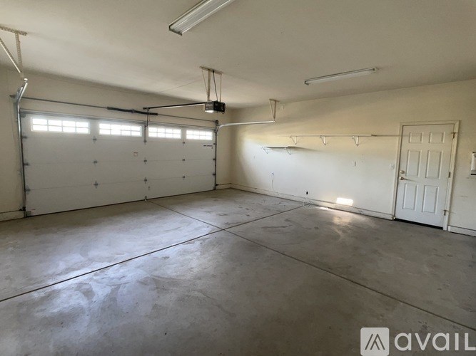 A large, empty garage with a concrete floor and white walls.