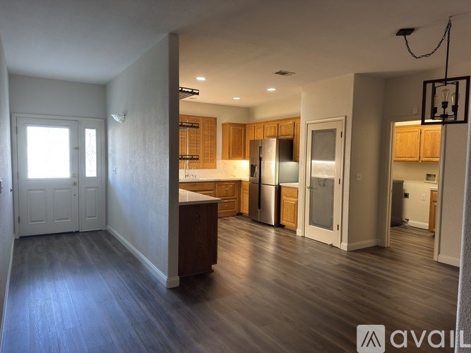 A spacious kitchen with wooden cabinets and a refrigerator.