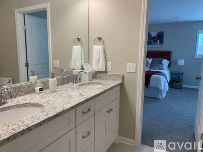 A bathroom with a marble countertop and a mirror above the sink.