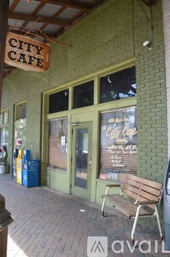 A city cafe with a brown bench outside.