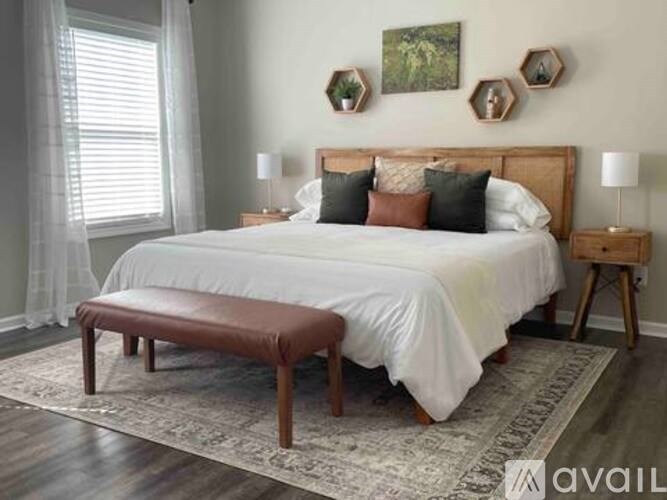 A bedroom with a large bed and a bench in front of it.