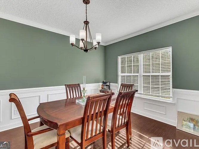 A dining room with a wooden table and chairs.
