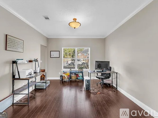 A room with a desk, chair, and a window with a view of a street.