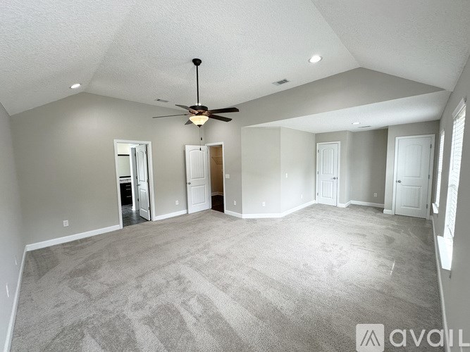 A bedroom with a bed, a fan, and a window.