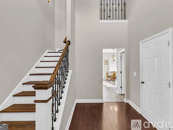 A staircase with wooden steps and a metal railing leads to a hallway.