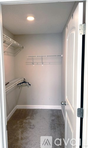 A bathroom with a large mirror, sink, and brown cabinets.