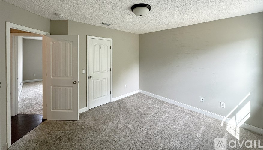 A white closet with clothes and a mirror.