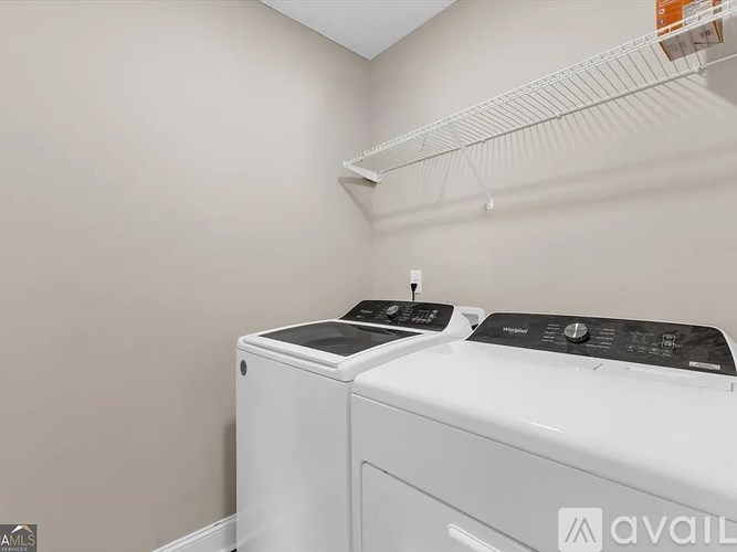 Two white front loading washing machines in a laundry room.