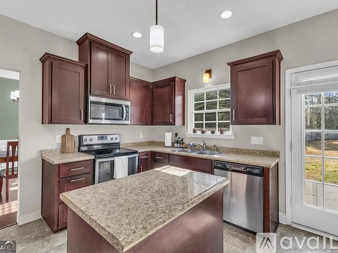 A kitchen with brown cabinets and a granite countertop.