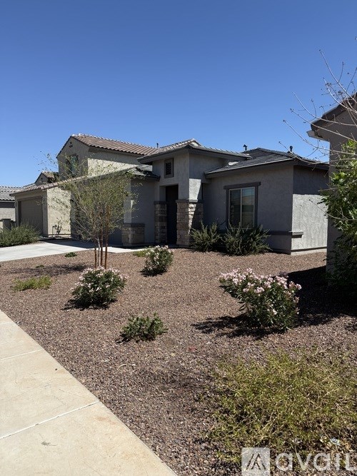 A house with a grey roof and a brown front yard.