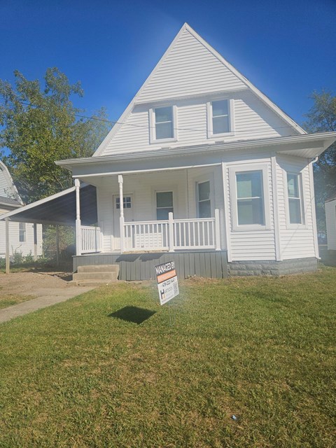 A house with a sign in front of it.