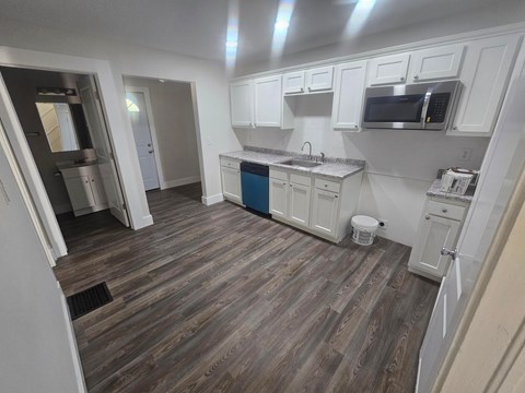 A kitchen with white cabinets and a blue island.
