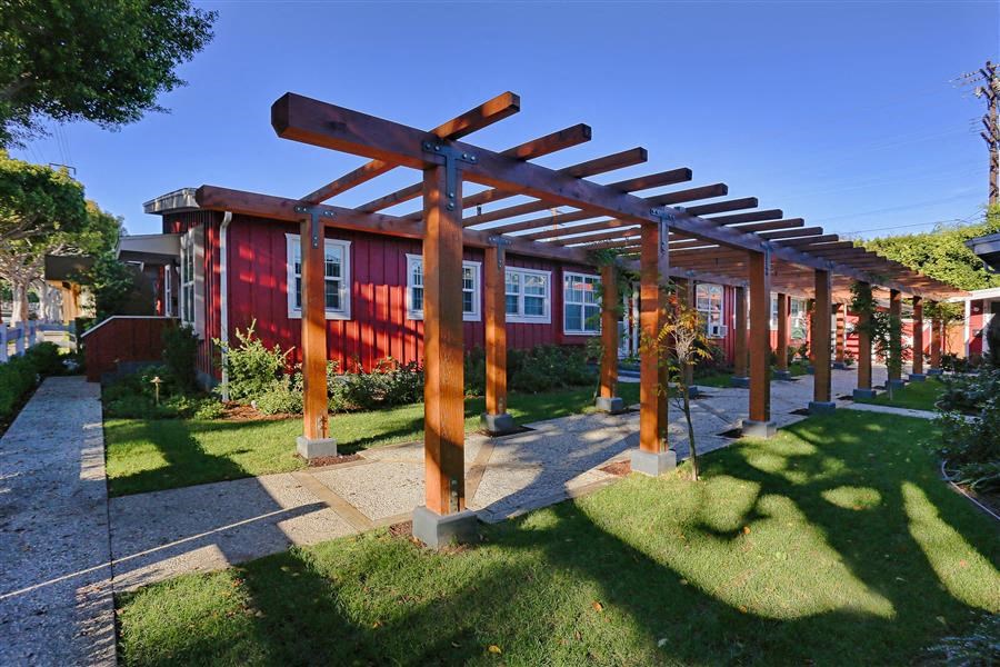 a red house with a porch with wooden beams