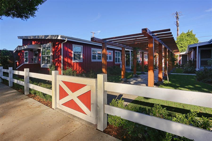 a red house with a red and white gate
