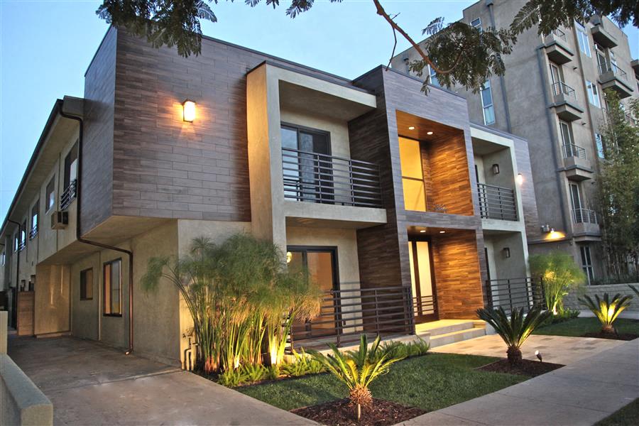 the facade of a modern home with a sidewalk and a courtyard