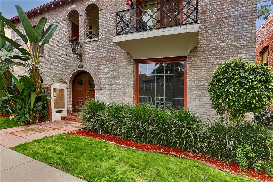 a brick house with a front yard and a balcony