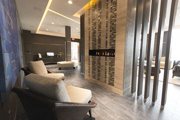 a lobby with chairs and a wall of wine bottles