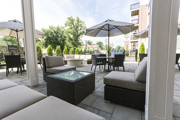 a patio with couches and chairs and an umbrella
