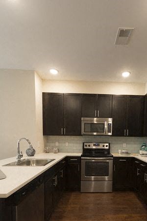 a kitchen with stainless steel appliances and black cabinets