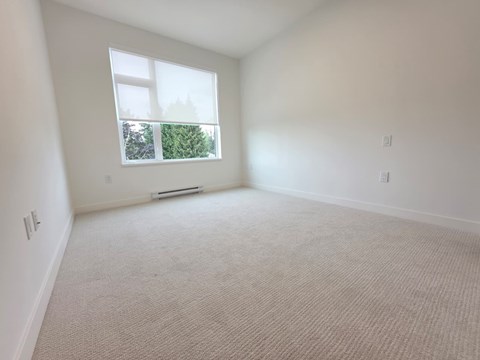 A room with a window and carpeted floor.