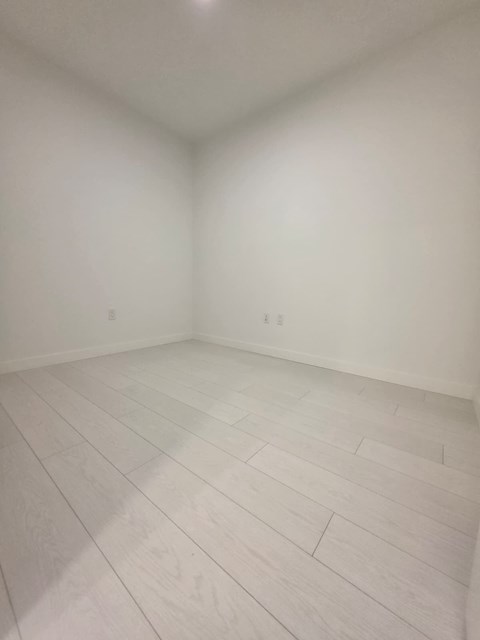 A room with white walls and a wooden floor.
