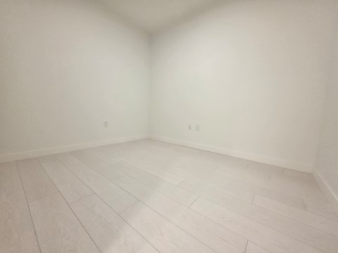 A room with white walls and wooden flooring.