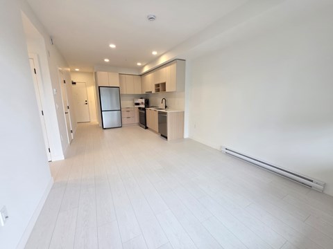 A spacious kitchen with a refrigerator, microwave, and oven.