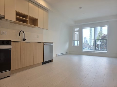 A kitchen with a black oven and a black faucet.