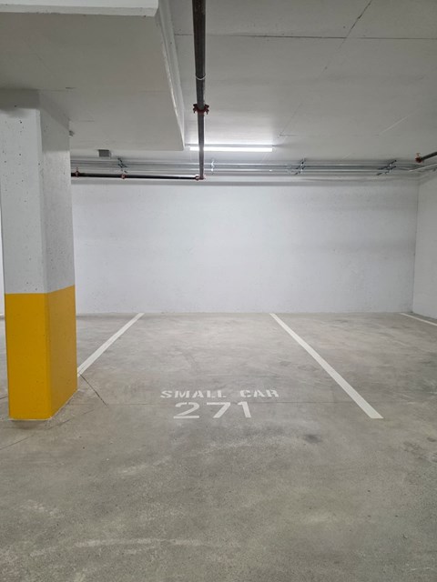 A parking garage with a yellow pole and a sign that says "small car 2771".