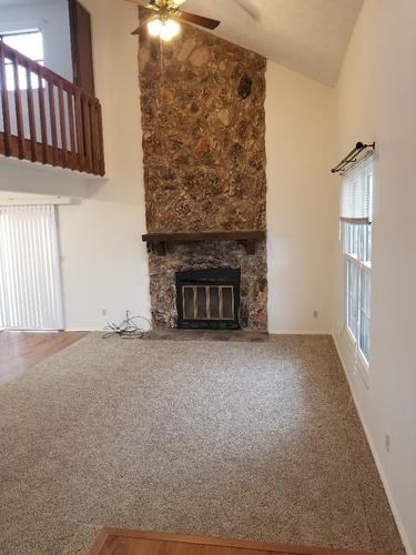 A room with a fireplace and a ceiling fan.