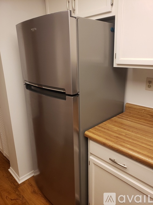 A kitchen with white cabinets and a wooden countertop.