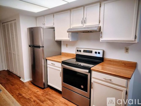 A kitchen with white cabinets and a wooden countertop.