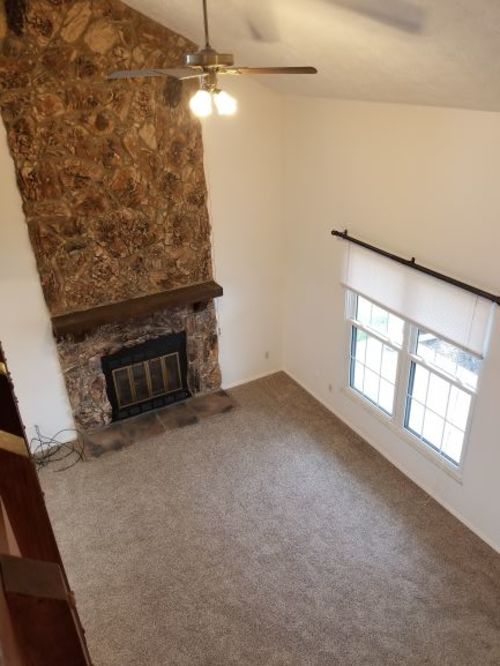 A room with a fireplace and a ceiling fan.