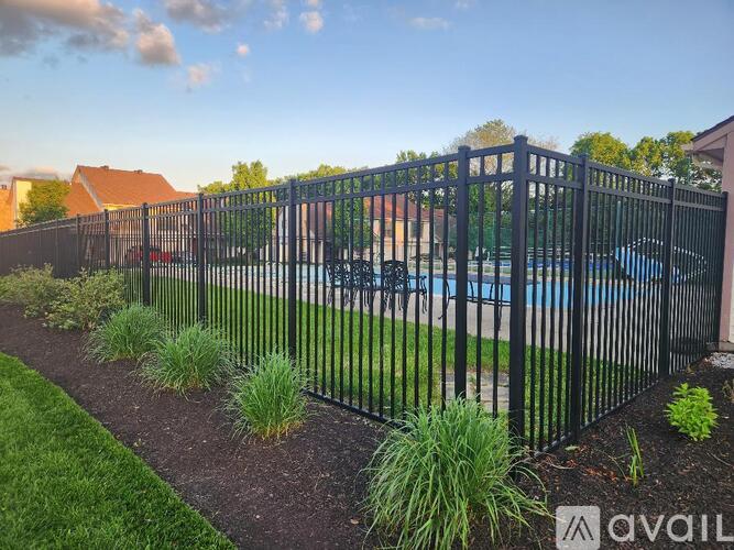 A black metal fence surrounds a pool area.