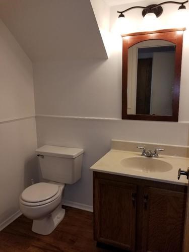 A white toilet sits next to a sink in a small bathroom.