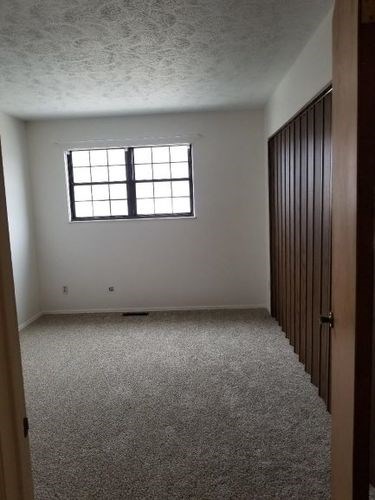 A room with a carpeted floor and a window.