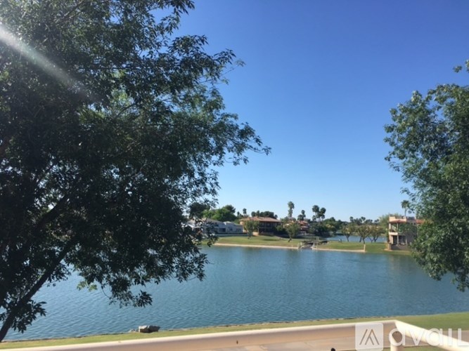 A lake surrounded by trees and buildings.
