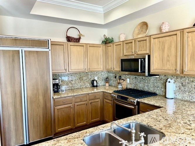 A kitchen with granite countertops and wooden cabinets.