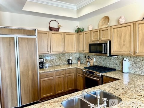 A kitchen with granite countertops and wooden cabinets.